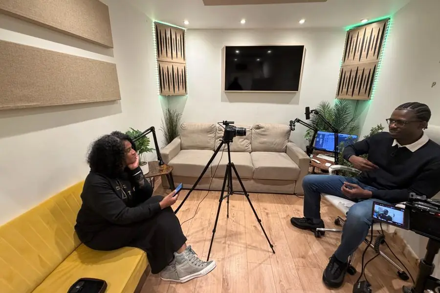 TRIYBE interviewing author and recording artist Ox Monica's Son in a recording studio, cameras set up between them