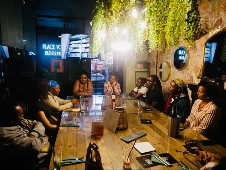 Guests around a long table in conversation at TRIYBE’s Black Hair and Identity brunch